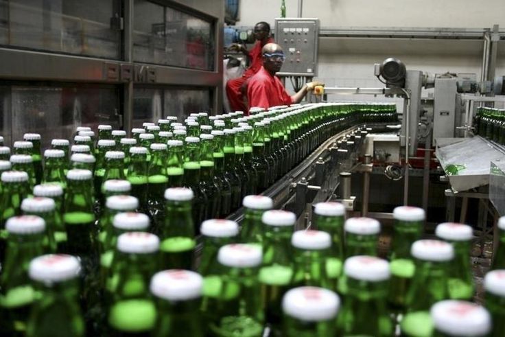 Technicians inspect beer bottles on a conveyor belt at a brewery in Gisneyi, western Rwanda, in a file photo. REUTERS/Hereward Holland