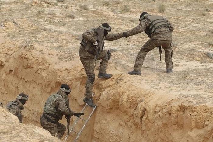 Tunisian soldiers participating in an exercise climb out of a trench, that forms part of a barrier along the frontier with Libya in Sabkeht Alyun,Tunisia February 6, 2016. REUTERS/Zoubeir Souissi