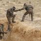 Tunisian soldiers participating in an exercise climb out of a trench, that forms part of a barrier along the frontier with Libya in Sabkeht Alyun,Tunisia February 6, 2016. REUTERS/Zoubeir Souissi