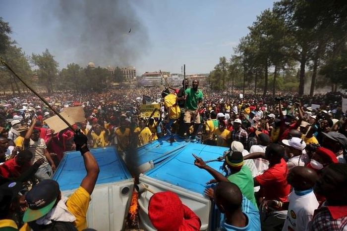 Protesters chant slogans as they burn portable toilets during a protest over planned increases in tuition fees outside the Union building in Pretoria, October 23, 2015. REUTERS/Siphiwe Sibeko