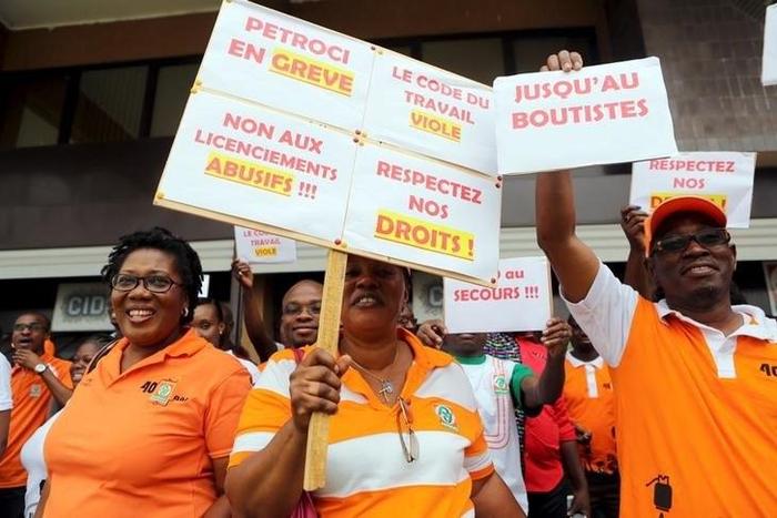 Striking workers at Ivory Coast's state oil company Petroci hold up signs during a 72-hour strike to protest a wave of recent layoffs in Abidjan, Ivory Coast, February 3, 2016. The signs say (clockwise from top right) "Until the end," "Respect our righ...