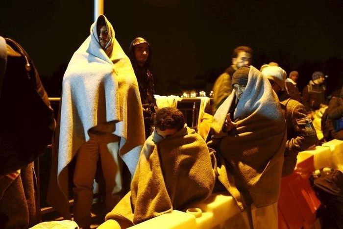 Migrants wait on the bridge at the Austrian-German border between Braunau and Simbach at lake Inn near Passau, Germany, October 27, 2015. REUTERS/Michaela Rehle