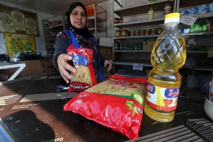 A worker sells subsidized food commodities at a government-run supermarket in Cairo, Egypt, February 14, 2016. Tens of millions of Egyptians rely on state subsidies provided as credits on smartcards they redeem against household staples each month. But...