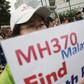 A woman whose relative was aboard Malaysia Airlines flight MH370 holds placard after police stopped protesting relatives from entering a road leading to the Malaysian embassy in Beijing August 7, 2015. REUTERS/Damir Sagolj