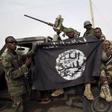 Nigerien soldiers hold up a Boko Haram flag that they had seized in the recently retaken town of Damasak, Nigeria, March 18, 2015.