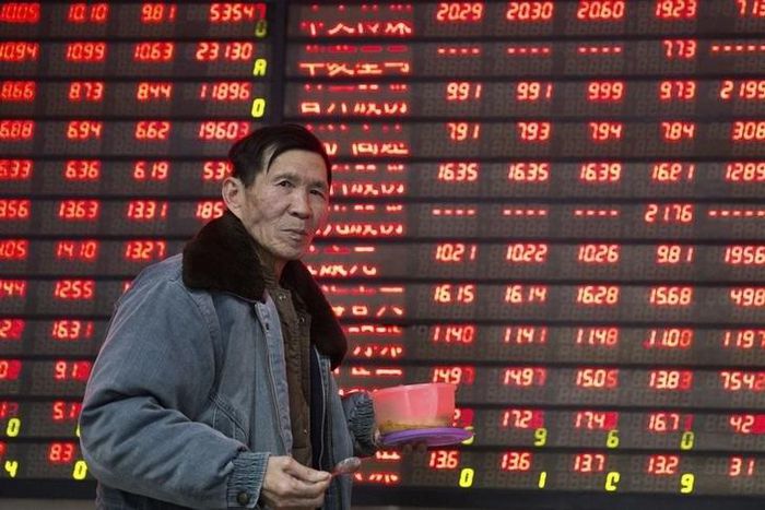 An investor walks past an electronic screen showing stock information at a brokerage house in Nanjing, Jiangsu province, China January 14, 2016. REUTERS/China Daily