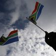 A hand is seen holding  a South African flag  in Pretoria, December 11, 2013.   REUTERS/Yannis Behrakis