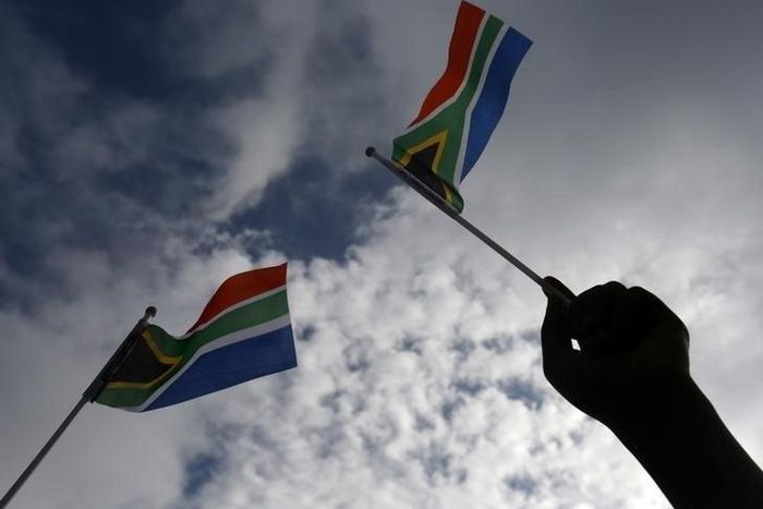 A hand is seen holding  a South African flag  in Pretoria, December 11, 2013.   REUTERS/Yannis Behrakis