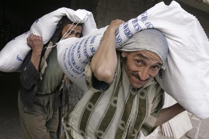 Workers carry sacks of rice in the Nile Delta town of Mansoura city, 210 km (130 miles) north of Cairo, in a file photo. REUTERS/Nasser Nuri