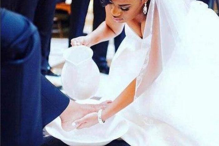 Bride washing her groom's feet