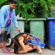 Beauty queen, Khanittha 'Mint' Phasaeng bows before her mum next to a row of wheelie bins