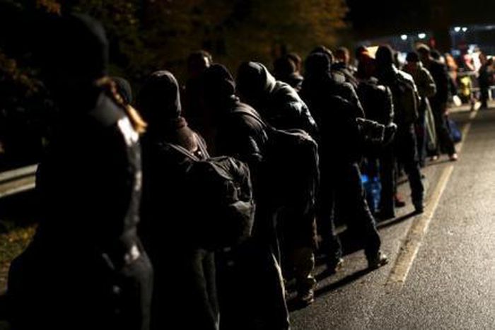 Migrants stay in a queue after crossing the Austrian-German border from Achleiten, Austria, in Passau, Germany, October 29, 2015.
