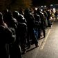 Migrants stay in a queue after crossing the Austrian-German border from Achleiten, Austria, in Passau, Germany, October 29, 2015.