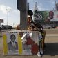 A student sits next to campaign posters of independent candidate Kouadio Konan Bertin, with a campaign billboard Ivory Coast President Alassane Ouattara seen in the background, ahead of the October 25 presidential election, in Abidjan October 21, 2015....