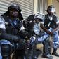 Riot policemen rest as they patrol a street in the Ugandan capital Kampala June 28, 2013. REUTERS/James Akena