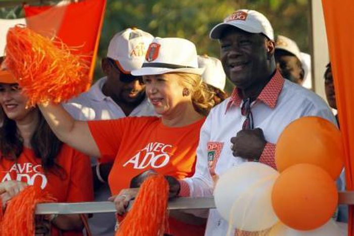Ivory Coast"s President Alassane Ouattara of the Rally of the Houphouetists for Democracy and Peace (RHDP) party and his wife Dominique Ouattara wave during his last campaign rally, ahead of the October 25 presidential election, in Abidjan on October 2...