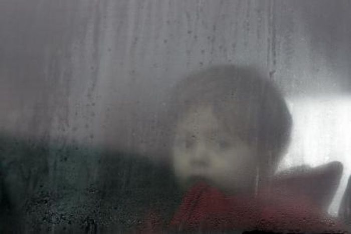 A migrant child sits in a bus on the way to a registration camp in Preshevo, Serbia, October 24, 2015.