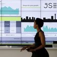 A worker walks past an electronic board displaying movements in major indices, at the Johannesburg Stock Exchange in Sandton, February 12, 2015. REUTERS/Siphiwe Sibeko