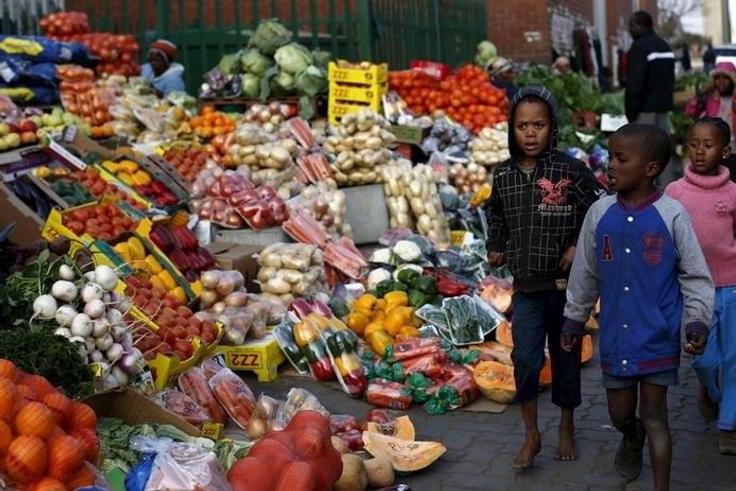 Children walk past a vegetable stall in Soweto July 23, 2015.    REUTERS/Siphiwe Sibeko