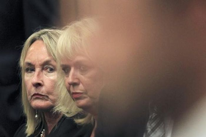 June Steenkamp (L), the mother of Reeva Steenkamp, glances at Oscar Pistorius as he sits in the dock ahead of the trial of the Olympic and Paralympic track star at the North Gauteng High Court in Pretoria March 3, 2014. REUTERS/Themba Hadebe/Pool
