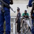 Residents look on as police and soldiers guard a voting station in Burundi's capital Bujumbura during the country's presidential elections, July 21, 2015. REUTERS/Mike Hutchings