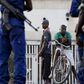 Residents look on as police and soldiers guard a voting station in Burundi's capital Bujumbura during the country's presidential elections, July 21, 2015. REUTERS/Mike Hutchings