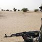 A Malian soldier, holding an AK-47 rifle, rides in a pick-up truck during a military escort outside Timbuktu, Mali, July 27, 2013.   REUTERS/Joe Penney