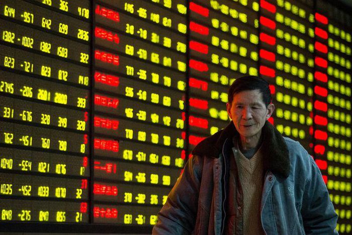 An investor walks past an electronic screen showing stock information at brokerage house in Nanjing, Jiangsu Province, China, January 11, 2016. REUTERS/China Daily