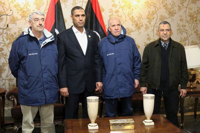 Tripoli-based Libyan Foreign Minister Ali Abu Zakouk (R) stands with Gino Pollicardo (L) and Filippo Calcagno (2nd R), two Italian civilians held hostage near the western Libyan city of Sabratha since last July, after they were freed, at Mitiga Interna...