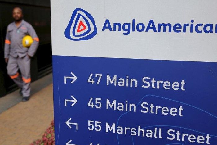 A worker walks past a board outside Anglo American offices in Johannesburg, August 21, 2015.   REUTERS/Siphiwe Sibeko