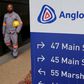 A worker walks past a board outside Anglo American offices in Johannesburg, August 21, 2015.   REUTERS/Siphiwe Sibeko