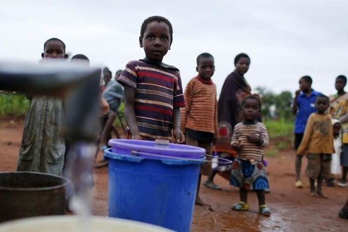 Children watch as women pump water from a borehole near Malawi's capital Lilongwe, February 2, 2016. REUTERS/Mike Hutchings