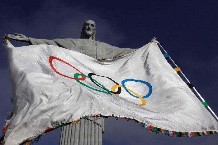 The Olympic Flag flies in front of "Christ the Redeemer" statue during a blessing ceremony in Rio de Janeiro August 19, 2012. REUTERS/Ricardo Moraes (