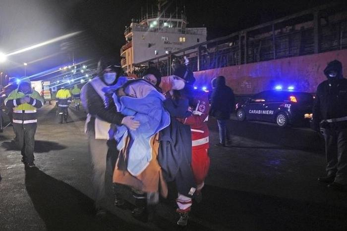 Medics help migrants after they arrived onboard the Blue Sky M cargo ship at the Gallipoli harbour southern Italy, December 31, 2014. REUTERS/Stringer