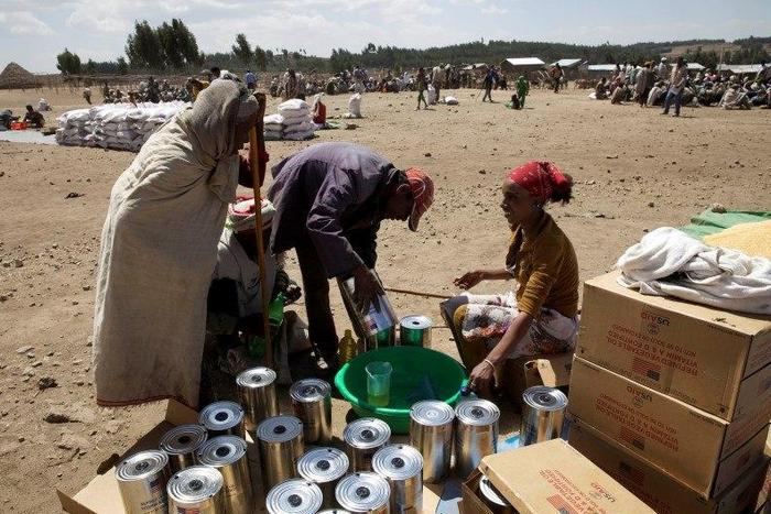 An elderly woman receives cooking oil at an emergency food aid distribution in the village of Estayish in Ethiopia's northern Amhara region, February 11, 2016. REUTERS/Katy Migiro