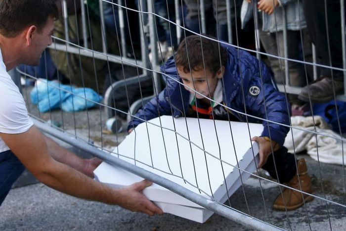 The kind gesture of a waiter delivering pizza to a group of migrants and refugees waiting behind a fence goes viral.