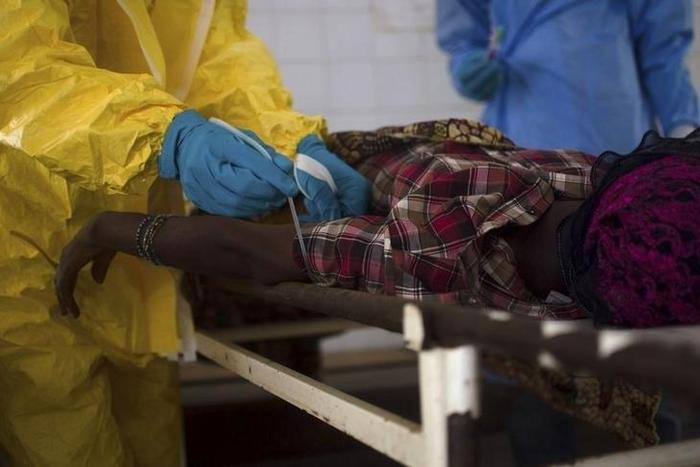 Medical staff take a blood sample from a suspected Ebola patient at the government hospital in Kenema, July 10, 2014. REUTERS/Tommy Trenchard