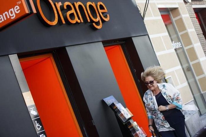 A woman walks past an Orange shop in Madrid, September 16, 2014. REUTERS/Andrea Comas