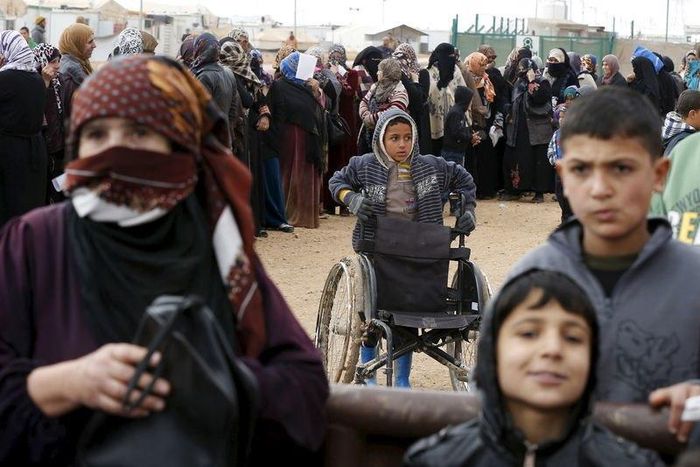 Syrian refugees stand in line as they wait for aid packages at Al Zaatari refugee camp in the Jordanian city of Mafraq, near the border with Syria, January 20, 2016. REUTERS/ Muhammad Hamed