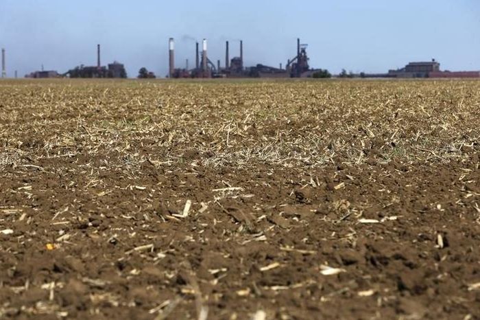 Chimneys from ArcelorMittal steel company are seen behind a dry maize field near Vanderbijlpark? outside Johannesburg, October 1 2015. REUTERS/Siphiwe Sibeko