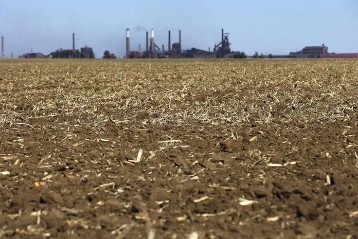 Chimneys from ArcelorMittal steel company are seen behind a dry maize field near Vanderbijlpark? outside Johannesburg, October 1 2015. REUTERS/Siphiwe Sibeko