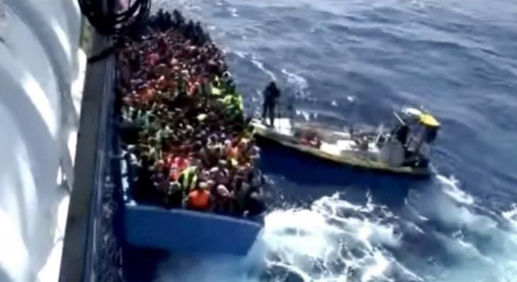 A boat full of migrants is seen next to Swedish ship Poseidon during a rescue operation in the sea off the coast of Libya in this still image taken from an August 26, 2015 video. REUTERS/Swedish Coast Guard Handout via Reuters TV -