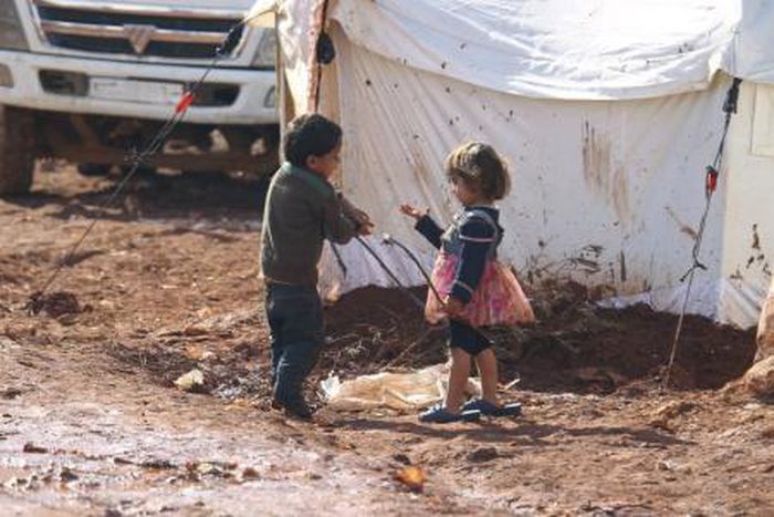 Children play outside tents housing internally displaced people in Atma camp, near the Syrian-Turkish border in Idlib Governorate, February 5, 2016.