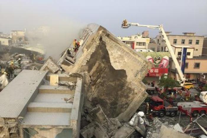 Rescue personnel work on damaged buildings after an earthquake in Tainan, southern Taiwan, February 6, 2016.