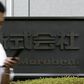 A man walks past a sign of Japanese general trading company Marubeni Corp at the company's head office in Tokyo July 27, 2009. REUTERS/Stringer