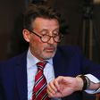 Sebastian Coe, IAAF's President, checks time ahead of a news conference by the World Anti-Doping Agency's (WADA) former president, Dick Pound, who heads the commission into corruption and doping in athletics, in Unterschleissheim near Munich, Germany, ...