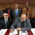 United Nations Special Representative and Head of the U.N. Support Mission in Libya Martin Kobler (C, top) looks on as representatives of Libyan municipalities sign documents to support Libya's new national government during a meeting in Tunis, Tunisia...