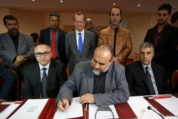 United Nations Special Representative and Head of the U.N. Support Mission in Libya Martin Kobler (C, top) looks on as representatives of Libyan municipalities sign documents to support Libya's new national government during a meeting in Tunis, Tunisia...
