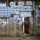 Election posters are seen pasted on a wall at the entrance to Benin Tennis Club, a day before the presidential election in Cotonou, March 5, 2016. REUTERS/Akintunde Akinleye