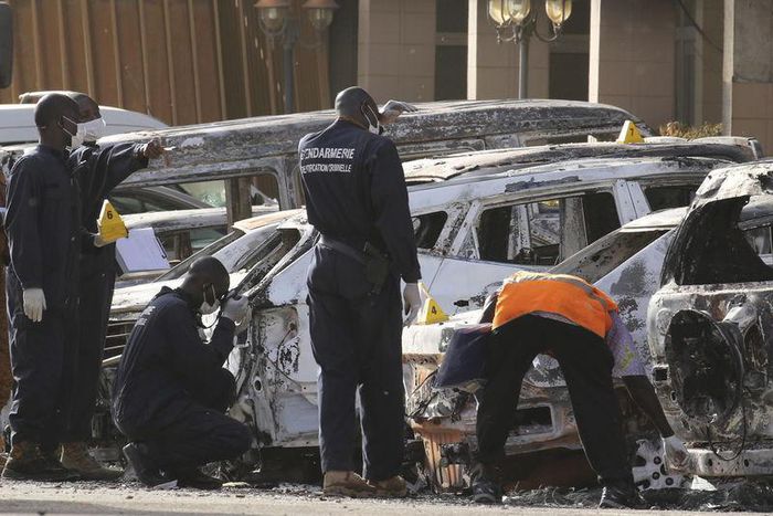 Gendarmes inspect burnt-out vehicles outside the Splendid Hotel in Ouagadougou, Burkina Faso, January 16, 2016, after security forces retook the hotel from al Qaeda fighters who seized it in an assault that killed two dozen people from at least 18 coun...